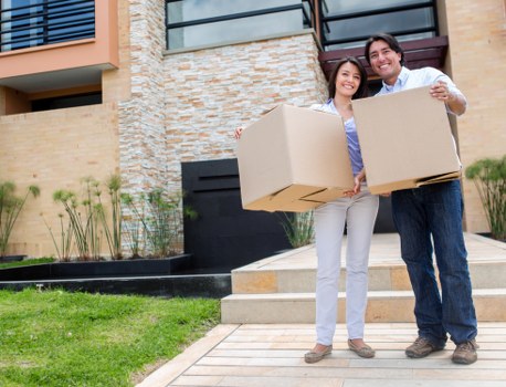 Mover wearing PPE while carrying furniture in an urban setting